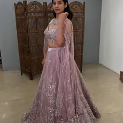 The side view of the mauve cape lehenga shows the beautiful flow and embroidery of this unique outfit.