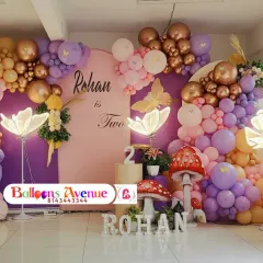 A wide view of the complete enchanted forest birthday decoration, showcasing the large marquee number '2' and the full balloon arrangement.