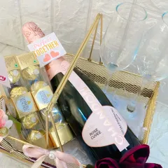 A close-up of the anniversary basket, showing the 'Perfect Together' tag, Ferrero Rocher chocolates, and a bottle of Chandon Rosé.