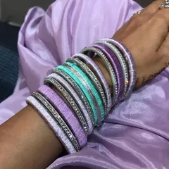 A close-up shot of the handcrafted silk thread bangles. You can see the detail of the thread wrapping and the sparkle of the accent bangles.