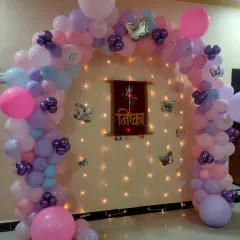 A butterfly-themed balloon arch for a naming ceremony at home. We used a wooden nameplate and fairy lights to create a warm and personalized backdrop.