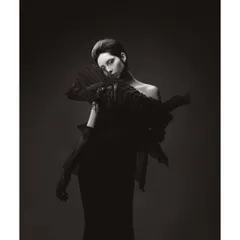 A dramatic black and white portrait of Athena. The high-contrast lighting and the sharp, angular shapes of the garment create a sense of tension and power.