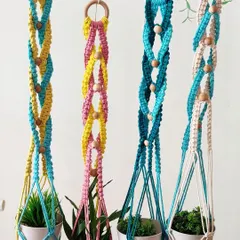 A set of four colorful plant hangers, each with a unique two-tone design. These are perfect for creating a vibrant, hanging garden indoors.