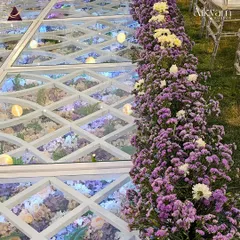 A detailed view of the floral glass aisle, bordered by a lush arrangement of purple and white flowers. This shows how we combine different elements to create a cohesive and beautiful design.