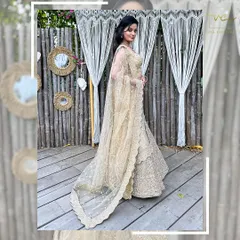 A side view of the beige lehenga, highlighting the delicate net dupatta with its scalloped border.