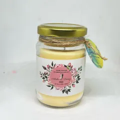 This scented soy wax candle in a jar features a custom floral label for a wedding celebration. The jute twine and small tag add a rustic, handmade touch to the favor.
