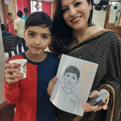 A proud birthday boy showing off his caricature portrait next to his mom. A live caricature artist is a unique entertainment option that also provides guests with a personalized party favor to take home.