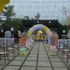 The entrance to the carnival was a long pathway decorated with a pastel balloon arch and lined with chairs, ready for the show to begin. A clown cutout and popcorn prop added to the fun.