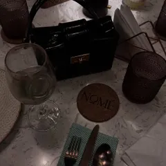 A flat-lay style shot of a chic black box bag on a dinner table, showing how a bag can be a centerpiece.