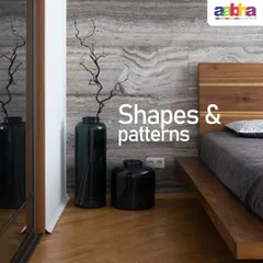 This bedroom showcases a sophisticated faux stone finish on the accent wall behind the bed. The natural, layered texture mimics the look of marble or travertine, creating a serene and luxurious atmosphere that pairs beautifully with the wooden bed frame and flooring.