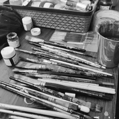 My tools of the trade. This black and white photo shows the beautiful mess of my paintbrushes after a productive session. Each one has helped tell a story on a wall somewhere.