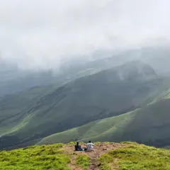 Two trekkers find a quiet spot to soak in the immense beauty of the Kudremukha landscape. We always encourage taking moments to appreciate the serenity.