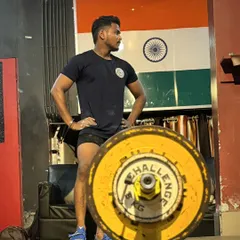 One of my athletes standing proud in front of the Indian flag. We lift for ourselves, for our team, and for our country.