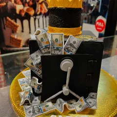 A different angle of the money vault cake, showing the detail on the vault door and the cascade of edible cash.