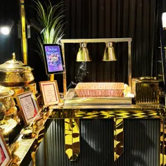 A sleek and modern live station setup with gold and black accents. The under-counter lighting and elegant heat lamps highlight our attention to contemporary design and sophisticated presentation.