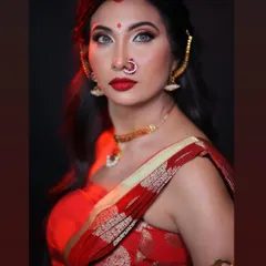 A striking close-up of the goddess look. The dramatic eye makeup, sharp contour, and bold red lip create a fierce and captivating portrait, enhanced by the studio lighting.