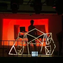 A silhouette shot from a Hip Hop Tamizha fan party. My custom geometric console and the massive VDJ screen are central to the visual identity of my sets.