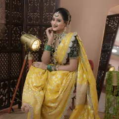 A classic Maharashtrian look featuring a beautiful yellow Paithani saree. The makeup is kept elegant with defined eyes and a traditional nath, perfectly complementing the rich black velvet blouse and green jewellery.