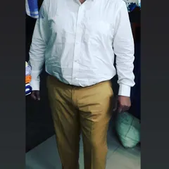 A classic white formal shirt paired with khaki trousers, both tailored for this client. I ensure the shirt has enough room in the shoulders and the trousers have the perfect break at the shoe.