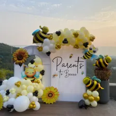 The perfect photo spot for the parents-to-bee. This custom backdrop with cute bee illustrations and a cheerful balloon garland was the centerpiece of a memorable baby shower.