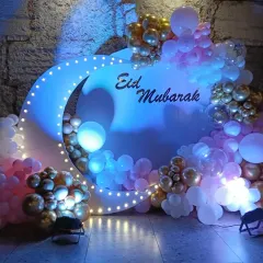 For a modern Eid celebration, I designed this beautiful photo booth. It features a large crescent moon with built-in lights, surrounded by a cascade of pastel and gold balloons for a festive and stylish look.
