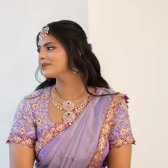 A side profile of our bride, showcasing the elegant drape of her lilac langa dhavani and the detailed craftsmanship of the blouse.