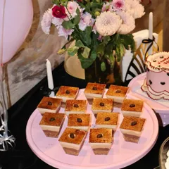 Our individual Tiramisu dessert cups are a party favorite. Here they are beautifully arranged on a pink cake stand, each topped with a coffee bean, ready for guests to enjoy.