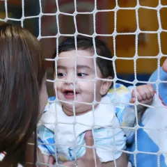A precious moment between parents and their baby at a birthday party, seen through the netting of a play area. Even in a busy event, I look for these small, intimate family interactions.