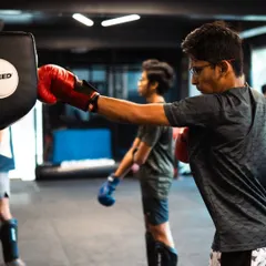 A student lands a clean cross on the focus mitts. This drill is fundamental for developing punching power and accuracy in our boxing and kickboxing lessons.