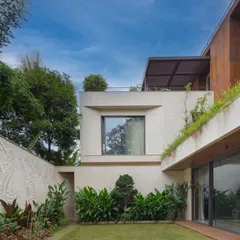 A view of the private lawn and courtyard, framed by a carved marble wall and lush greenery. I design these spaces to be tranquil sanctuaries within the larger property.