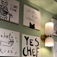 A closer look at some of the witty and charming illustrations, including "Yes Chef" and "Wash Your Hands." This type of cafe art helps build a unique brand personality.