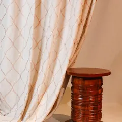 A close-up of one of our custom curtain designs. This elegant fabric features a delicate, embroidered trellis pattern that adds a layer of texture and sophistication to the window dressing.