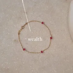 A close-up of my 'árvat' Ruby Baati Bracelet, a delicate piece designed to attract wealth and alleviate gloomy moods.