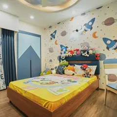 Another look at the rocket-themed room, showing the custom-designed wardrobe with a mountain-peak pattern. The curtains also have a fun, playful print that ties into the room's theme.