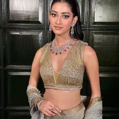 A full-length view of this golden glam look. The shimmering lehenga and sleek ponytail create a modern and chic silhouette, perfect for a Sangeet or reception party.