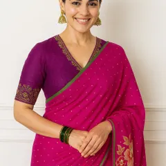 A playful and chic combination, contrasting the purple blouse with a vibrant rani pink saree.
