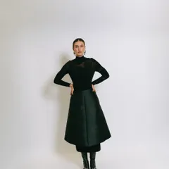 A classic full-length studio portrait against a white backdrop, showcasing a chic, all-black outfit for a model's book.