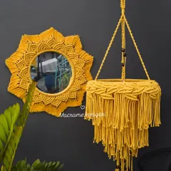A vibrant yellow macramé mirror and matching chandelier-style plant hanger. This set is perfect for adding a bold and sunny statement to your decor.