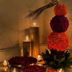 For Diwali, I love creating welcoming arrangements for a guest's arrival. This one-of-a-kind display features a topiary of marigold and gomphrena spheres, surrounded by bowls of petals and glowing candles.