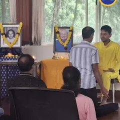 A devotee participates in a purification ceremony during a Sunday satsang. This simple ritual is a powerful way to affirm our intention to release limitations and open to the Guru's grace.