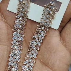 These elegant, leaf-patterned dangler earrings are made with marquise-cut American diamonds. The design is simple yet very sparkly, making them a great choice for both Indian and Western outfits.