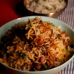 A comforting bowl of our home-style chicken biryani. You can see the long-grain basmati rice layered with tender chicken, fried onions, and fresh herbs. It’s the perfect meal for when you need something satisfying and full of flavour.