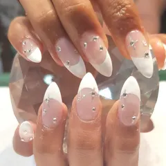 These almond-shaped nail extensions feature a modern French tip and delicate crystal embellishments. This is a popular choice for clients heading on vacation or for brides wanting a touch of sparkle.