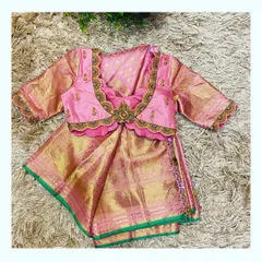 This is a closer look at a custom-designed blouse for a child's Pattu Pavadai, a traditional South Indian outfit. I crafted this piece from rich pink silk with a scalloped neckline and delicate hand embroidery to perfectly match her mother's saree, creating a beautiful and memorable twinning moment.