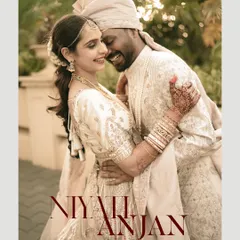 A joyful, candid portrait of the couple in their beautiful ivory wedding attire, sharing a genuine laugh.