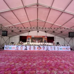 The stage setup for a major political event. We construct large, elevated platforms complete with professional lighting trusses, sound systems, and branding banners to meet the specific needs of public functions.