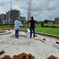 Surveying a new construction site against the backdrop of the city. I assess the land's slope, energy, and surrounding environment before planning the Vastu layout.