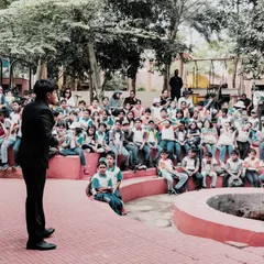 Addressing a school assembly in an outdoor amphitheater. I have extensive experience as a school event magician, providing entertainment that is both fun and engaging for students of all ages.