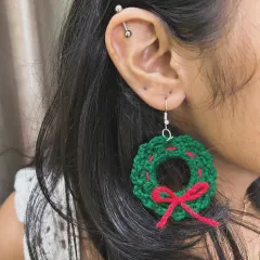 Get into the festive spirit with my Christmas wreath earrings. This design features a green wreath with red bow details, perfect for holiday parties.