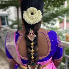 Another beautiful example of a traditional bridal braid, decorated with a large jasmine veni and elaborate hair accessories.